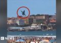 Fighter jet swerves dramatically to avoid birds near packed beach